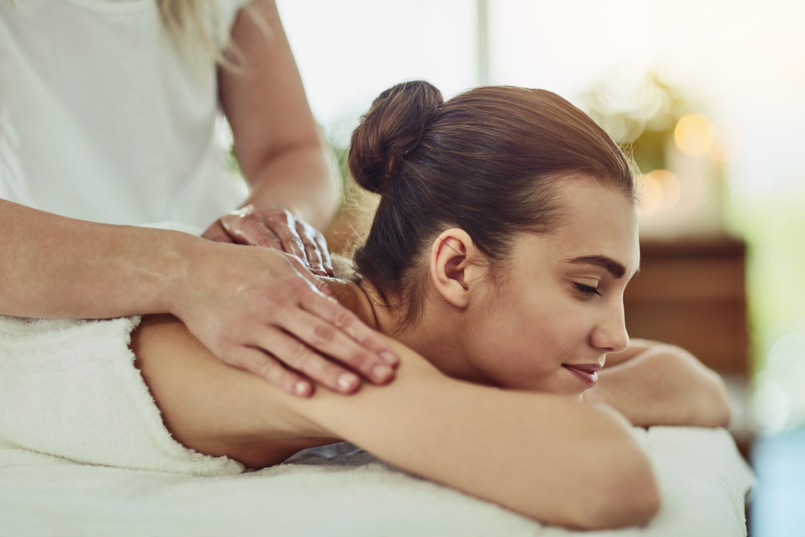 a young woman getting massaged at a beauty spa