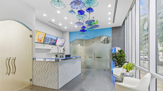 biostation reception with a white welcome desk and blue glass ceiling art