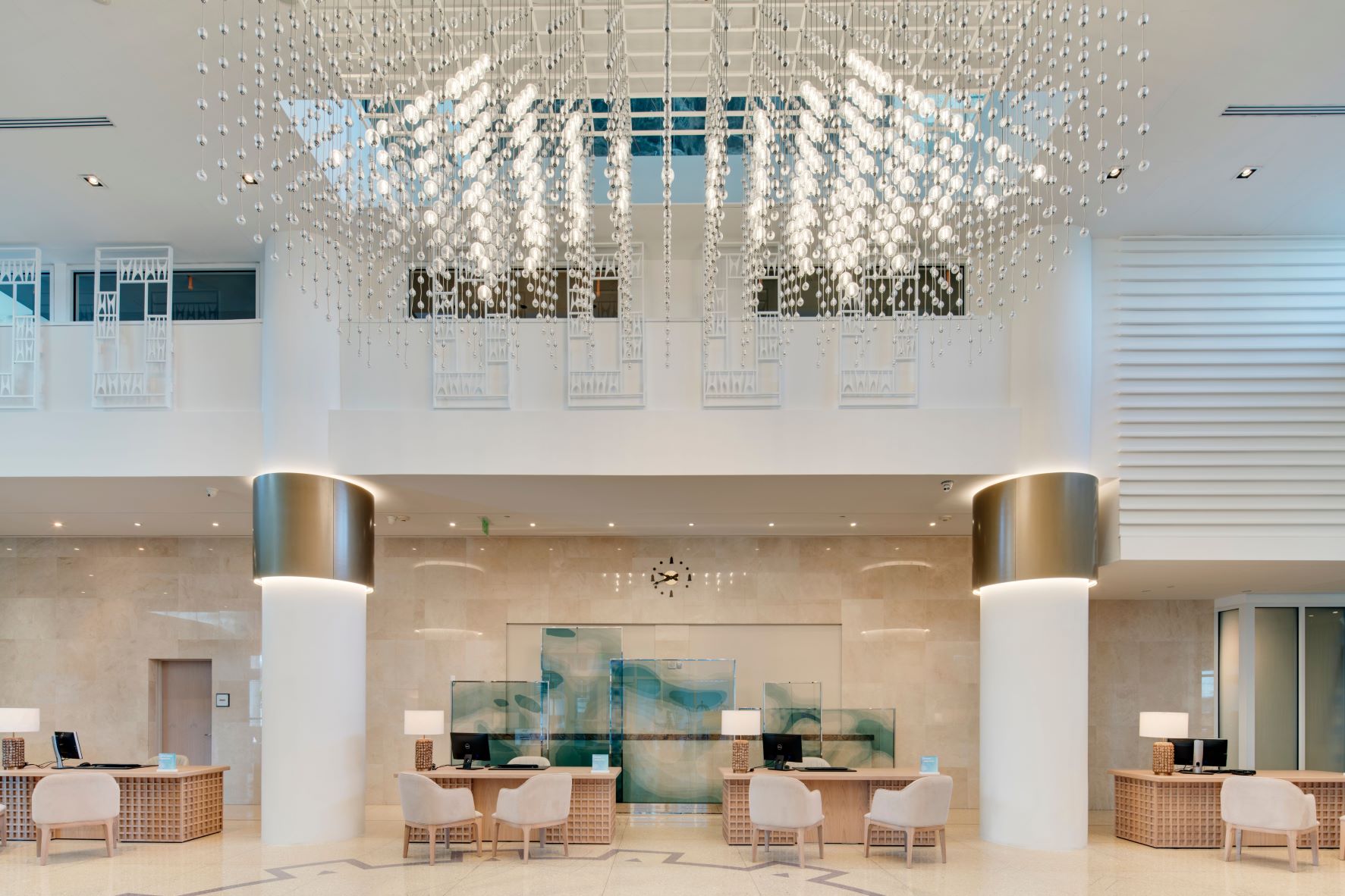 Image of the Carillon's lobby which includes reception desks and a string light chandelier